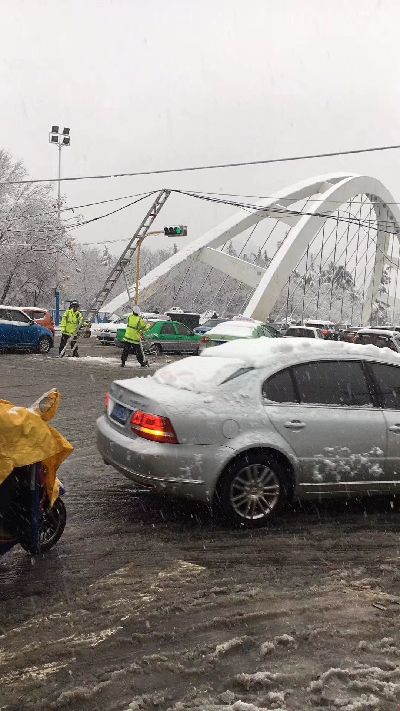 合肥蒙城路桥大雪压电缆挂住公交车 民警爬到车顶托举20多分钟