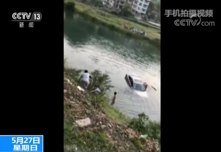 女子驾驶轿车失控冲入河中 路人紧急救助