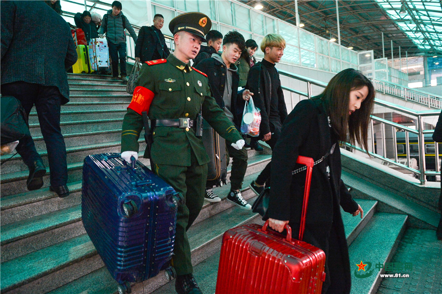 图为在重庆北站候车大厅，执勤的武警官兵正在维护秩序。