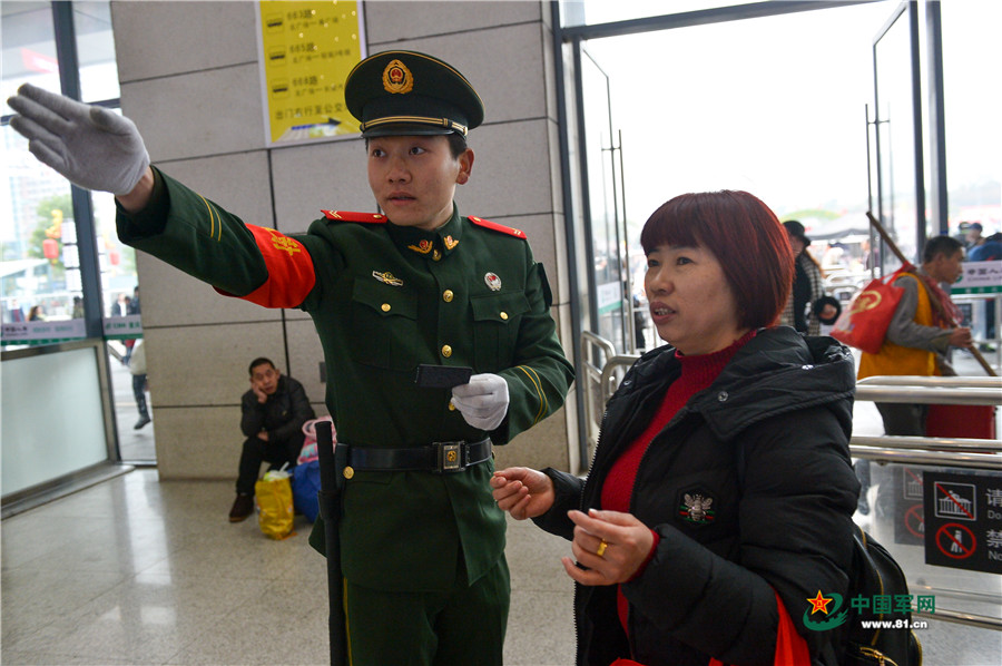 图为在重庆北站候车大厅，执勤的武警官兵正在维护秩序。